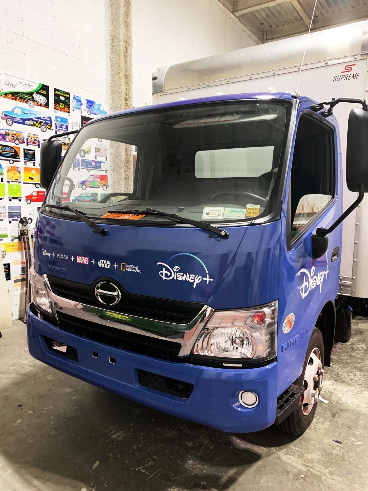 Disney+ branded truck wrap showcasing prominent logos of Disney, Pixar, Marvel, Star Wars, and National Geographic, emphasizing vehicle advertising as a marketing strategy.