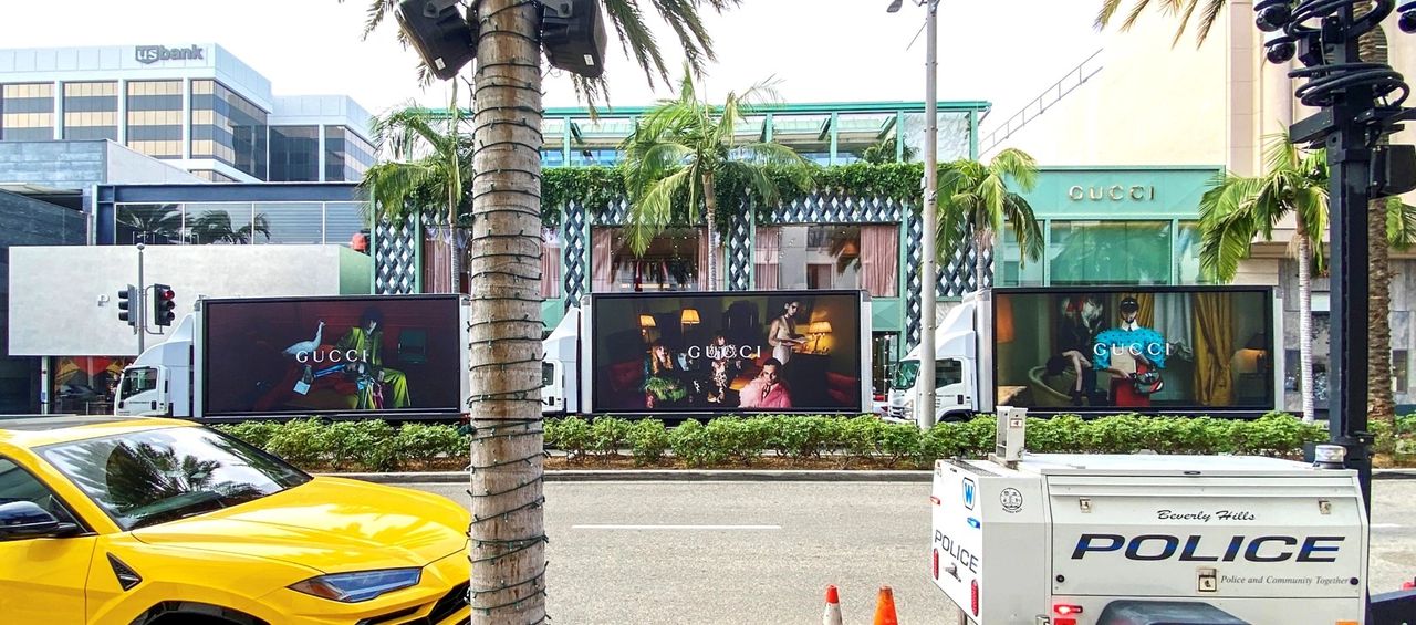 Mobile billboards displaying Gucci advertisements in a high-traffic area of Los Angeles, featuring vibrant visuals and branding, enhancing brand visibility and engagement.