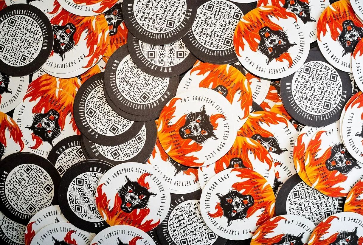 Colorful circular stickers featuring a fierce black panther surrounded by flames, QR codes, and the phrase "PUT SOMETHING EXCITING BETWEEN YOUR LEGS," representing innovative guerilla marketing strategies.