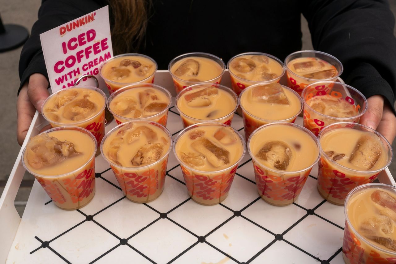 It's essential to secure the necessary permissions before launching a guerilla marketing campaign. Dunkin' iced coffee cups with cream and ice, displayed at a guerilla marketing pop-up shop, emphasizing interactive brand engagement.