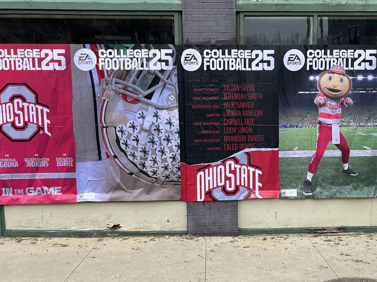 Ohio State University football promotional banners featuring players and mascot, highlighting "College Football 25" by EA Sports, emphasizing brand visibility and engagement in urban advertising.
