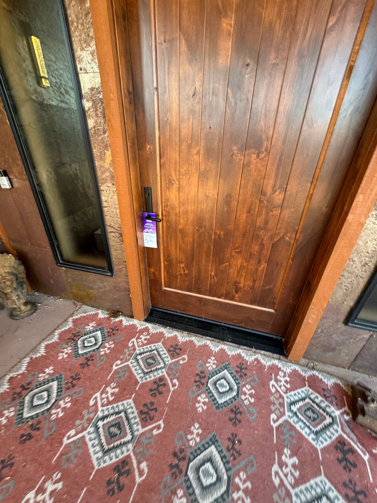 Door with a door hanger promotion attached, set against a patterned rug, highlighting direct-to-door marketing for local businesses in Indiana.
