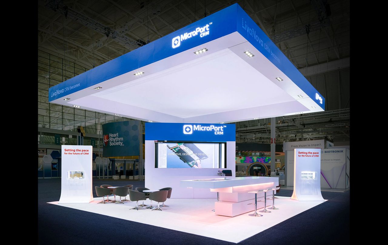 Trade show booth for MicroPort CRM featuring sleek design, digital display, and promotional text "Setting the pace for the future of CRM," emphasizing innovative marketing strategies.