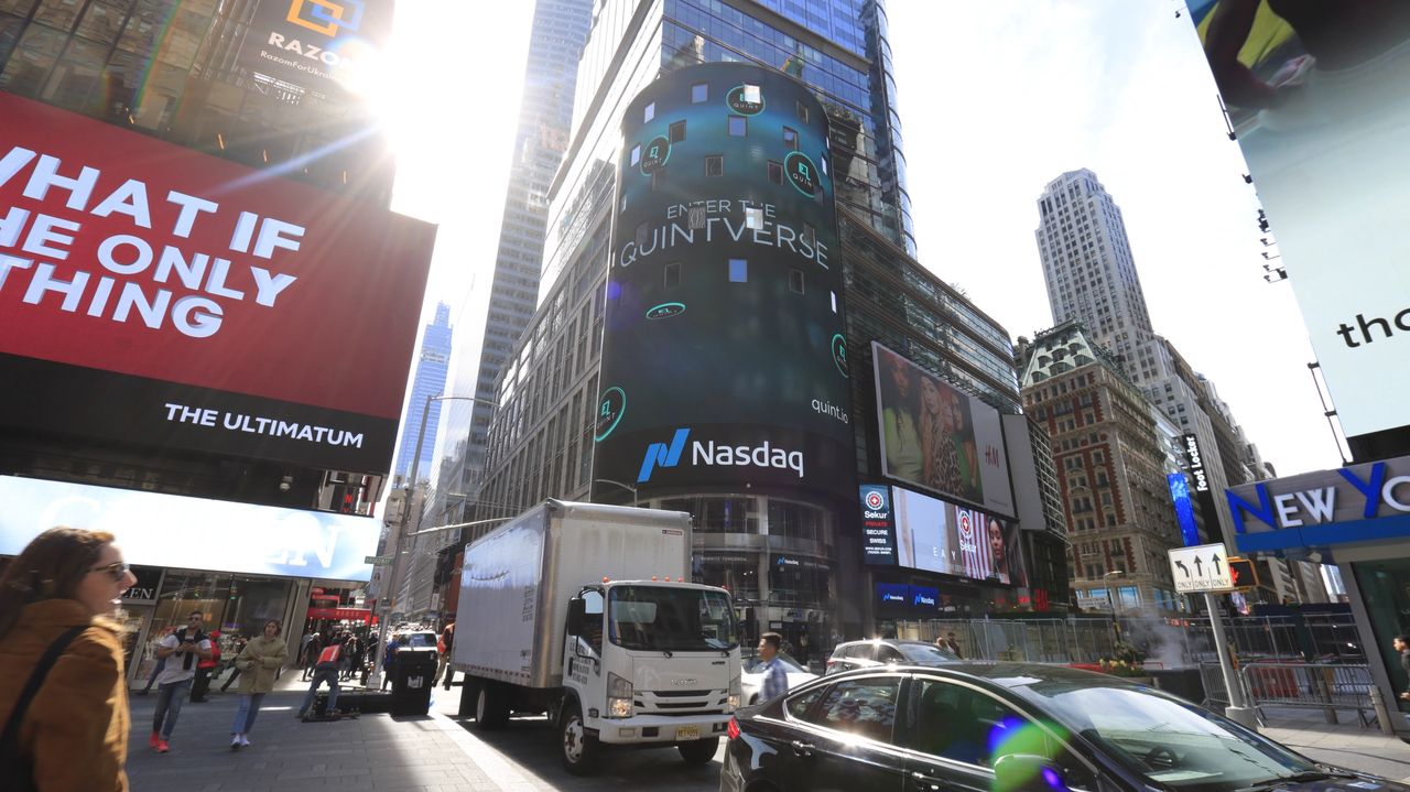 Times Square billboard featuring Nasdaq logo and "Enter the Quintiverse" advertisement, surrounded by bustling pedestrians and vibrant digital ads.