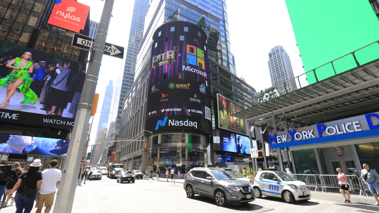 Billboard advertising featuring Nasdaq and Microsoft in Times Square, showcasing digital media trends and advertising strategies, with pedestrians and vehicles in a bustling urban environment.