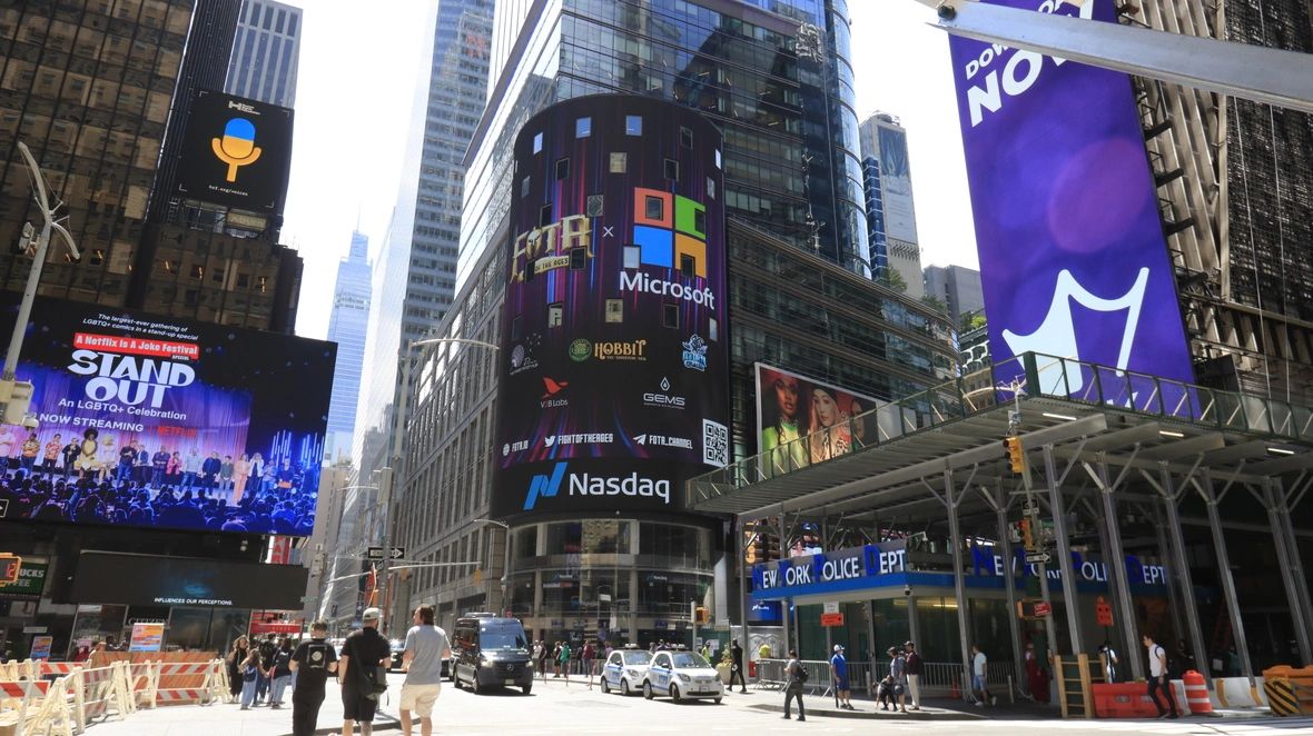 NASDAQ billboard in Times Square displaying advertisements for Microsoft and a Netflix event, with pedestrians and traffic in the foreground.