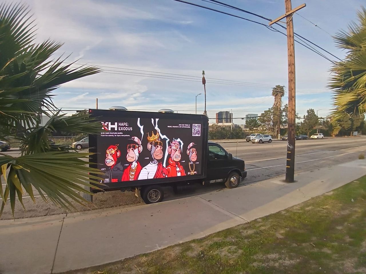LED advertising truck featuring vibrant graphics of cartoon monkeys, promoting "HAPE: EXODUS," parked along a busy street in Los Angeles, surrounded by palm trees and urban scenery.