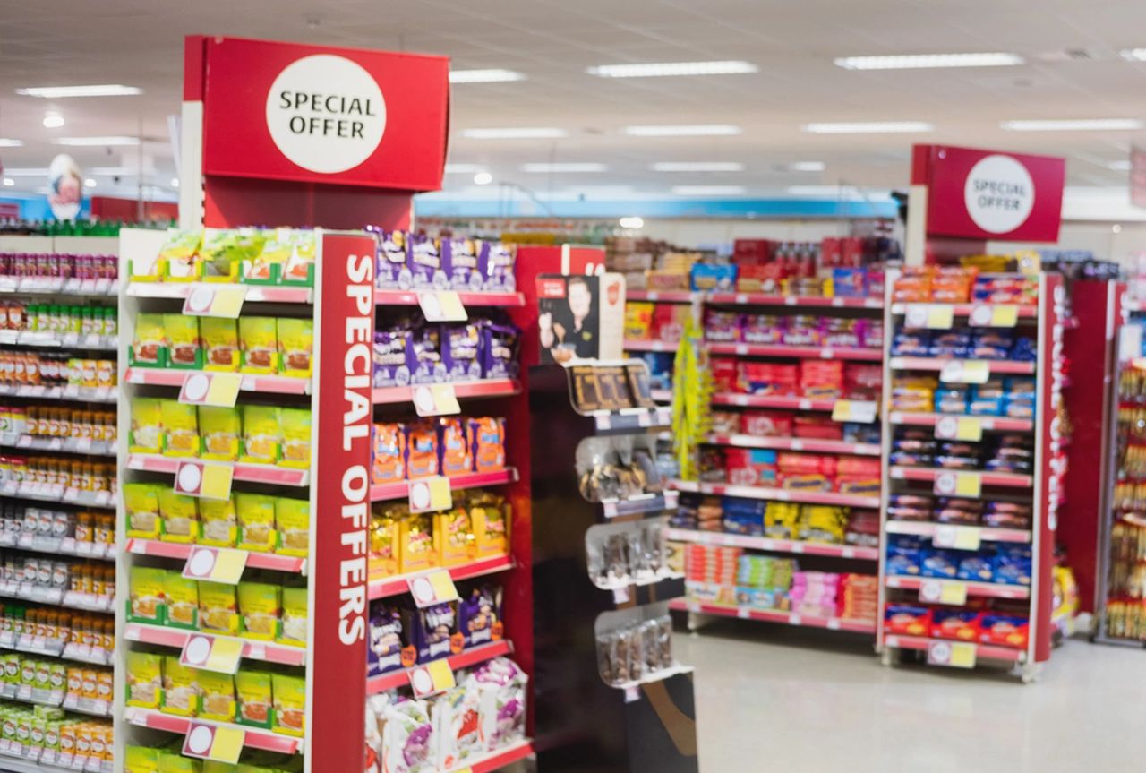 Grocery store aisle featuring colorful displays of snacks and products with "Special Offer" signage, illustrating effective point of sale advertising strategies to enhance customer engagement and boost sales.