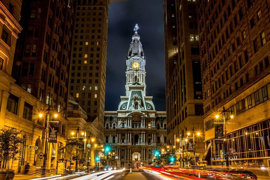 Philadelphia City Hall illuminated at night, surrounded by tall buildings and light trails from passing vehicles, symbolizing urban vibrancy and advertising potential in Philadelphia.