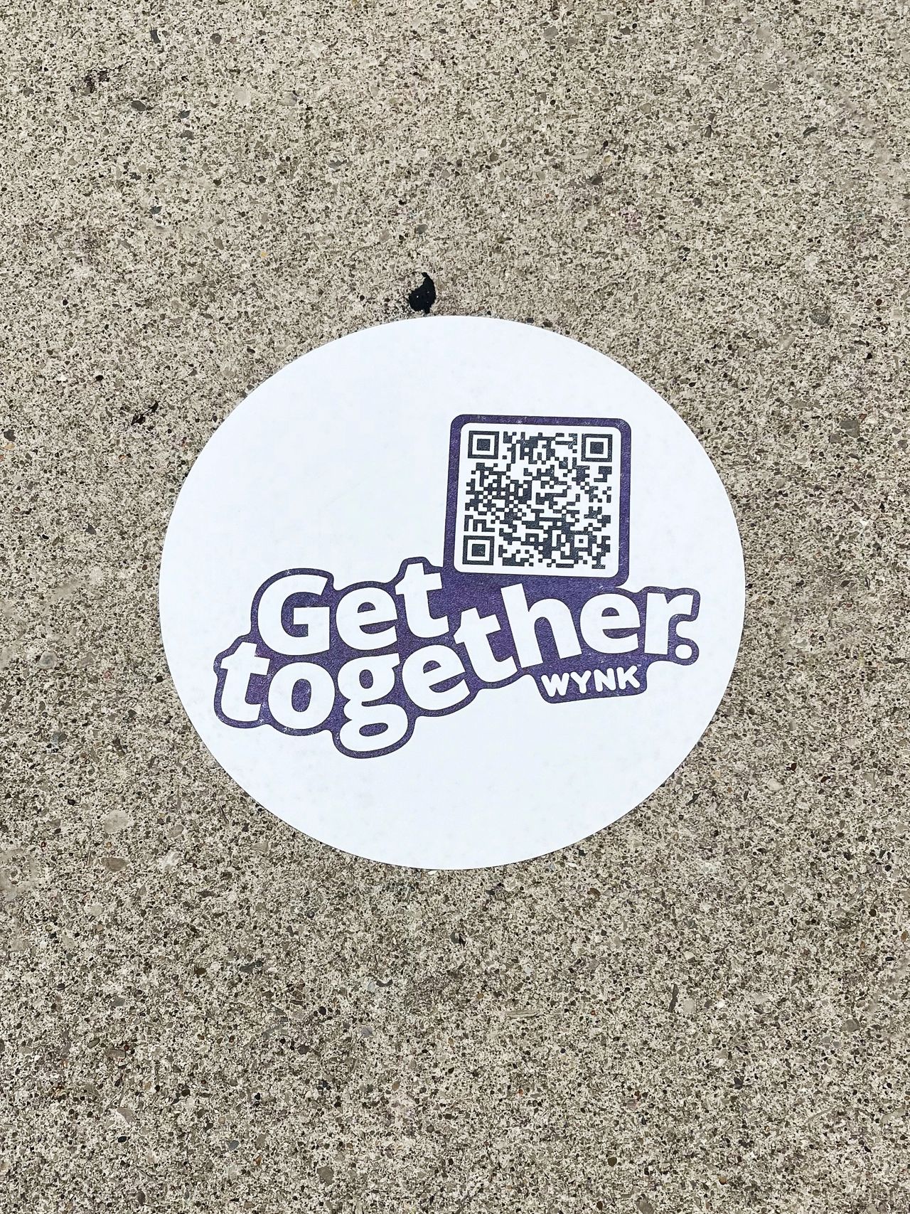 Sidewalk decal featuring the text "Get together" and a QR code, promoting engagement in urban settings for guerrilla marketing strategies in San Francisco.