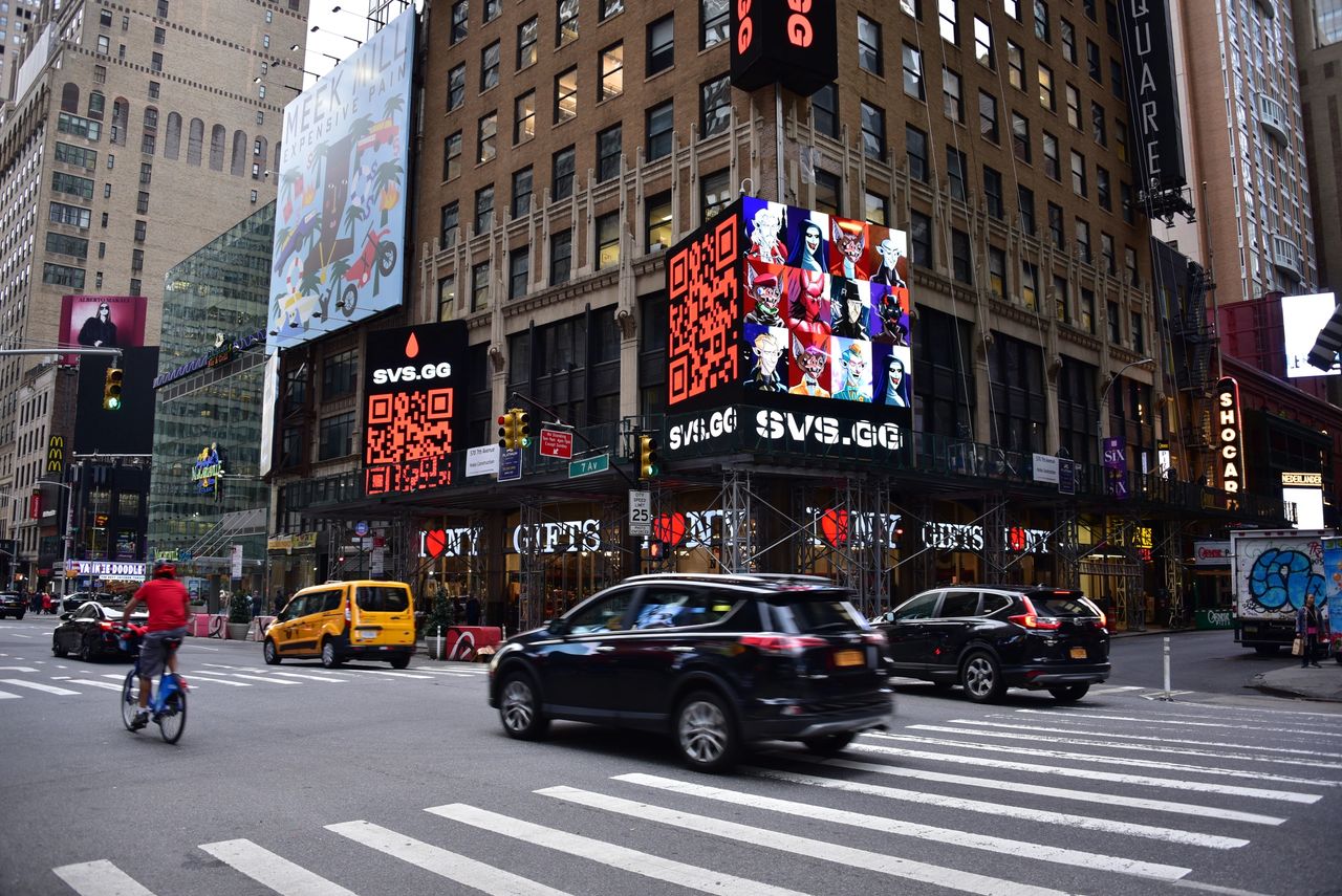 Times Square billboard advertising featuring digital ads for SVS.gg, vibrant visuals with QR codes, and storefronts displaying "I &hearts; NY GIFTS."