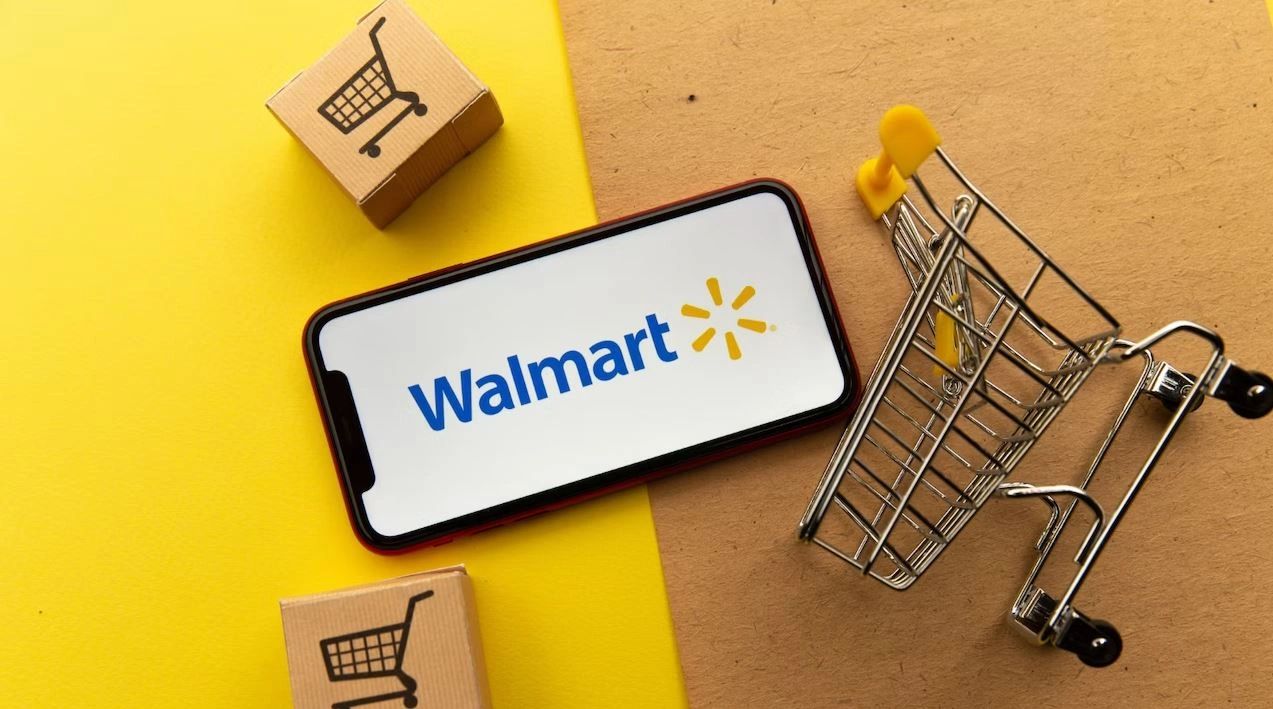 Walmart logo displayed on smartphone screen alongside shopping cart and delivery boxes, symbolizing innovative in-store advertising strategies.