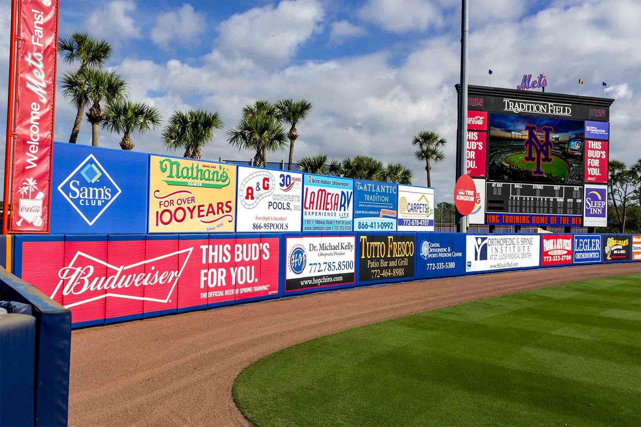Stadium advertising signage at Tradition Field featuring brands like Budweiser, Nathan's, and Sam's Club, highlighting opportunities for enhanced brand visibility and engagement during sports events.