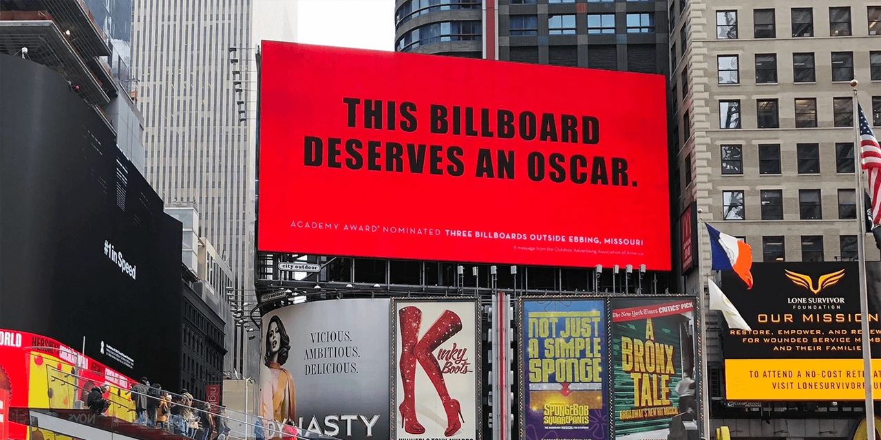 Billboard in Times Square displaying bold text "THIS BILLBOARD DESERVES AN OSCAR" promoting the film "Three Billboards Outside Ebbing, Missouri," highlighting the impact of movie advertising.