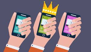 Hands holding smartphones displaying mobile ads, with one phone featuring a crown, symbolizing effective mobile advertising strategies and user engagement.