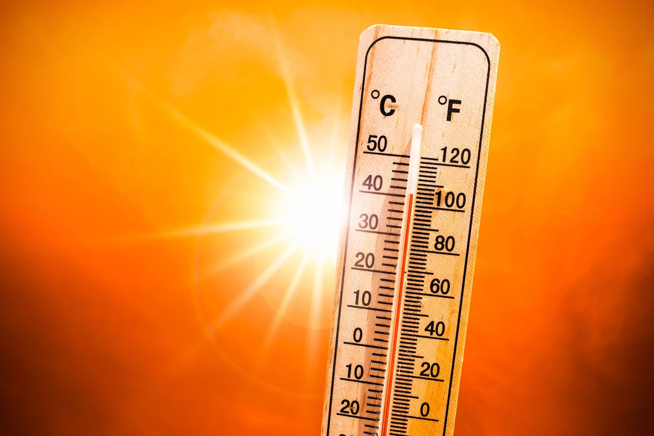 Thermometer showing high temperatures against a bright orange background, symbolizing summer heat and heatwave marketing strategies.