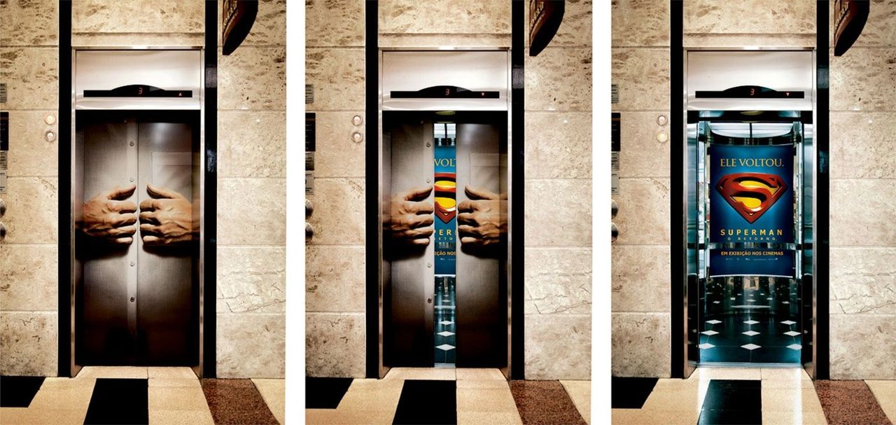 Elevator door graphic featuring hands pulling apart to reveal a Superman movie poster, promoting emotional engagement in cinema advertising.