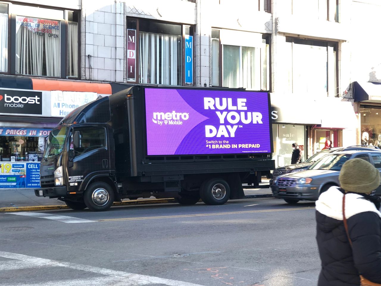 Yes, LED truck billboards can be a highly effective form of advertising for companies seeking innovative and unconventional marketing strategies to stand out in the market. LED truck billboard displaying "metro by T-Mobile" advertisement with the slogan "RULE YOUR DAY" in a vibrant purple background, showcasing modern mobile marketing strategy in an urban setting.