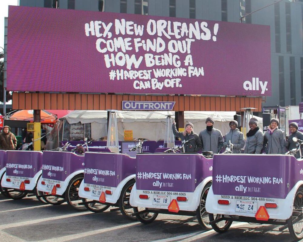 Pedicabs lined up with promotional signage for Ally, featuring the text "Hey, New Orleans! Come find out how being a #HardestWorkingFan can pay off," showcasing an engaging form of guerrilla marketing in an urban setting.