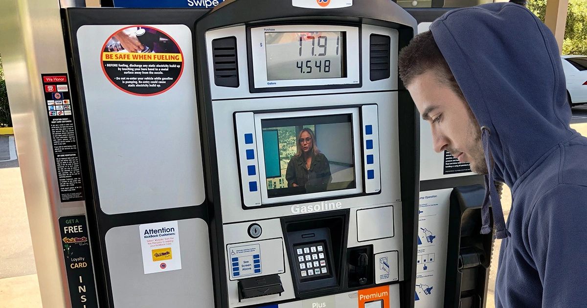 Gas pump with digital screen displaying video advertisement, man interacting with the pump, emphasizing gas pump TV advertising effectiveness.