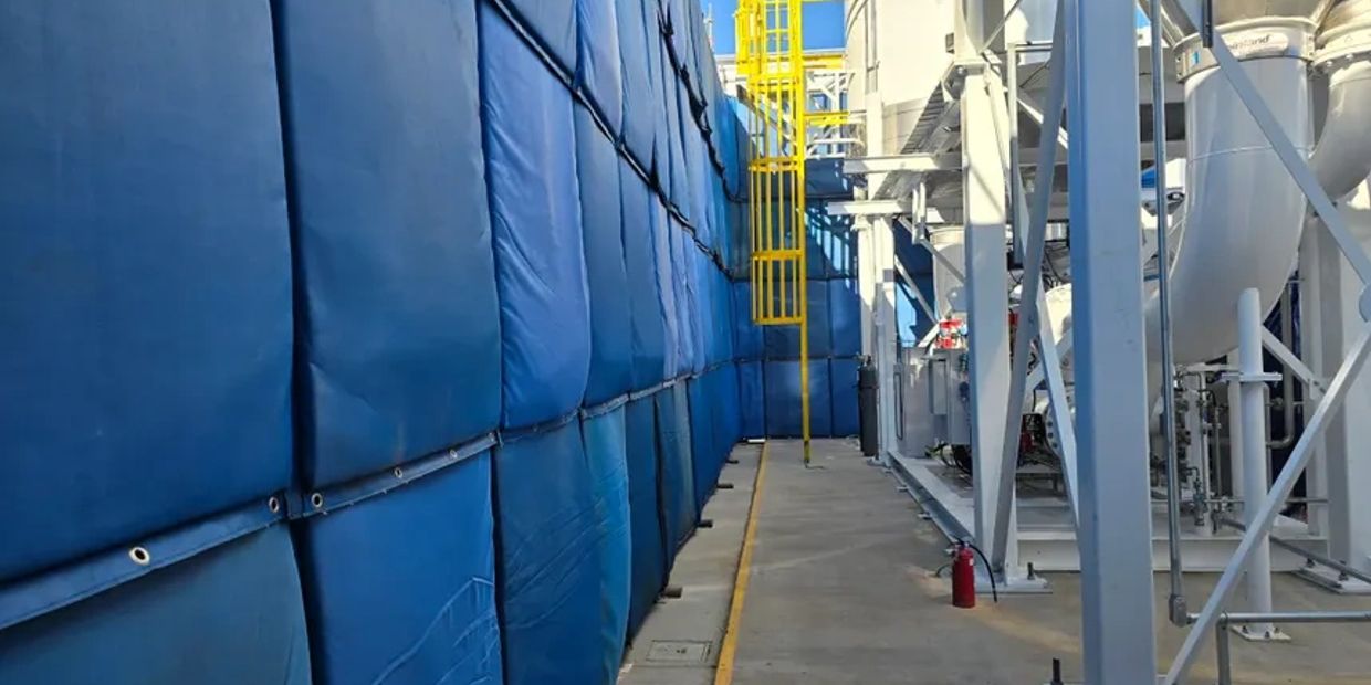 Industrial area with blue weatherproof noise barriers used to control noise.