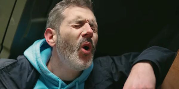 Man sneezing with eyes closed.