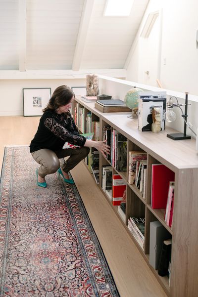 Long low lying book case being organized by a professional organizer in Kingston, Ontario. 