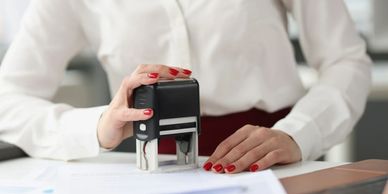 Person stamping a document with a self-inking stamp.