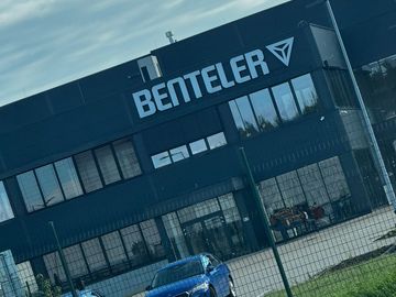 Blue car parked outside a Benteler building.