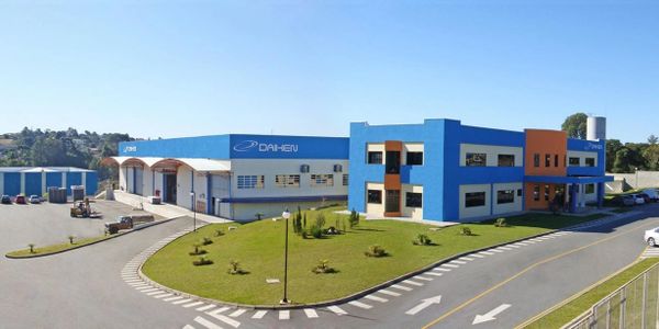 Modern industrial building with blue and orange accents under clear skies.