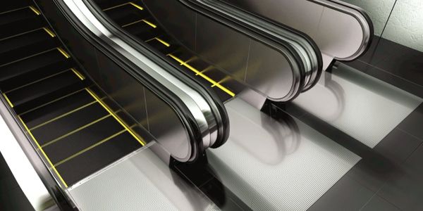 Modern escalators with yellow-lit steps in a sleek, clean environment.