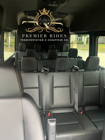 Interior of a luxury passenger van with Premier Rides branding.