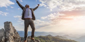 man over on peak of mountain