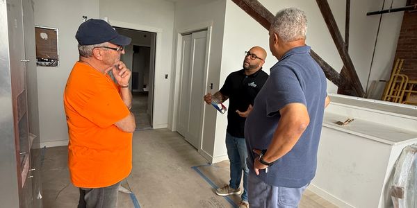 Three men discussing something indoors.