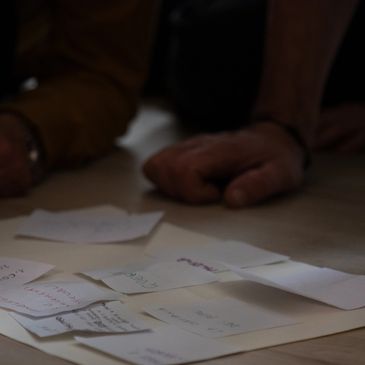 Hands resting near scattered handwritten notes on a table.