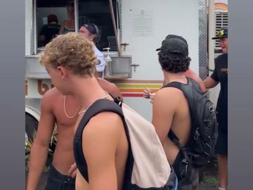 Group of young men gathered near a food truck.