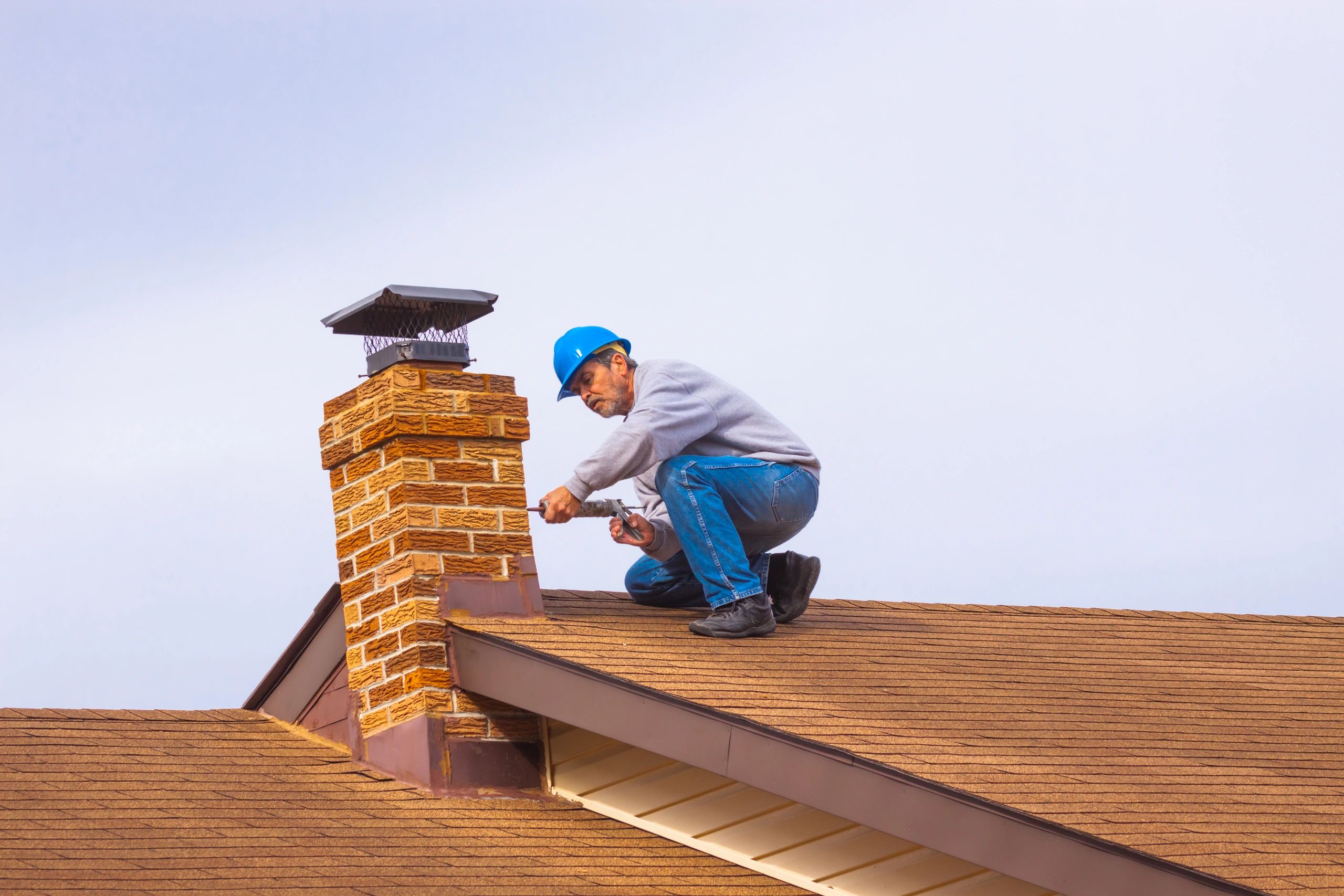 a man on a roof tuckpointing