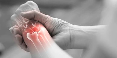 Hand holding a wrist with highlighted pain area in red.