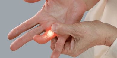 Hand massaging a finger with highlighted pain area.