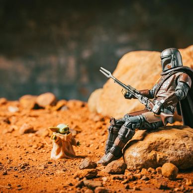 Star Wars Mandalorian and Grogu figures on rocky terrain.