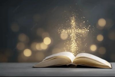 Open book with glowing cross of light rising above it.