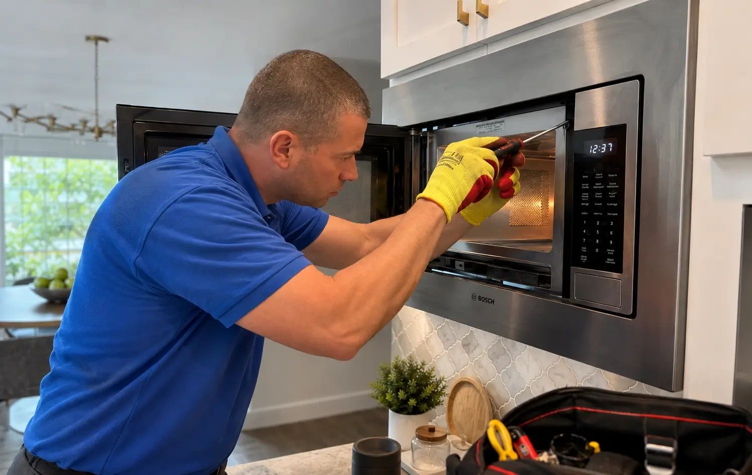 Technician repairing a built-in Bosch microwave in a home kitchen in Austin, TX