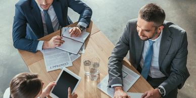 Three professionals having a business meeting at a table.