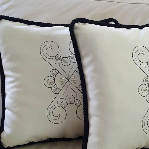 Embroidered and beaded pillows with trim