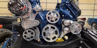 Close-up of a car engine with pulleys and belts.