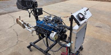 Exposed engine mounted on a frame with gauges.