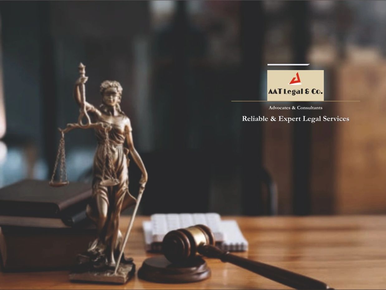 Lady Justice statue and gavel on desk with AAT Legal & Co. logo.