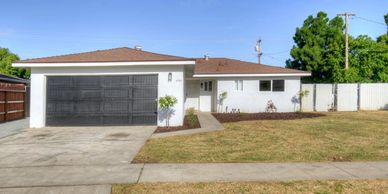 Single-story house with brown roof and black garage door.