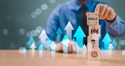 Person stacking tiles with top tile saying Skills. 