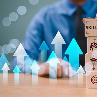 Man building block of tiles with Skills block at the top.